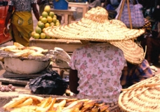 Woman grilling plantain in food market