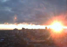 Sol entre la ciudad y las nubes