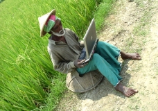 :: A Rural Farmer in front of Paddy Field with Mobile PC ::