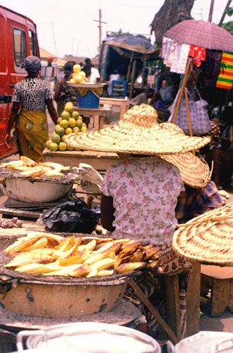 Woman grilling plantain in food market