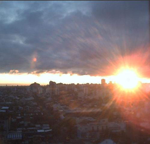 Sol entre la ciudad y las nubes
