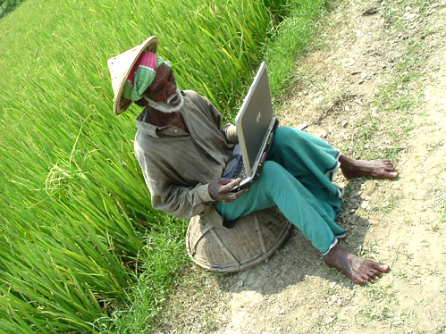 :: A Rural Farmer in front of Paddy Field with Mobile PC ::