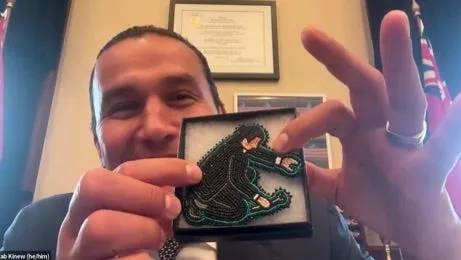 Premier Wab Kinew showing beadwork of him